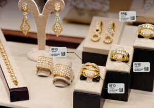 Gold jewelry display with UHF RFID labels attached to rings, earrings, and bracelets for jewelry inventory tracking and luxury retail management